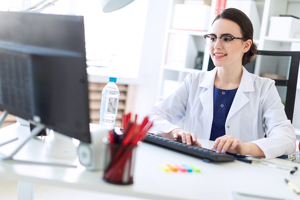 Dentist looking at a computer screen and smiling.