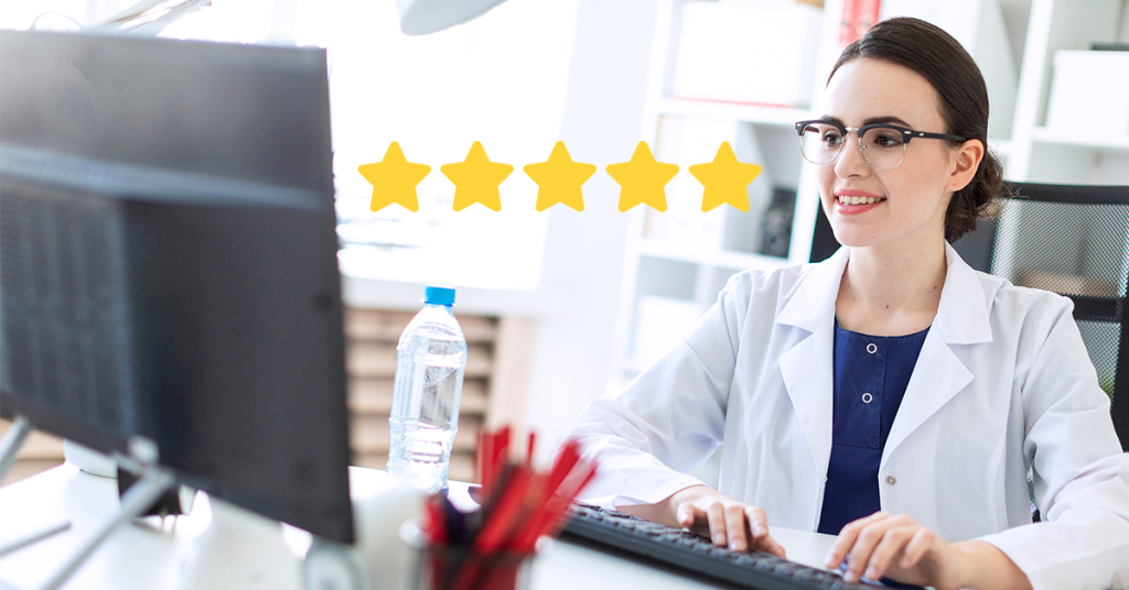 A dentist sitting at a desk and using a computer and smiling. Next to the computer there is a graphic of 5 golden stars.